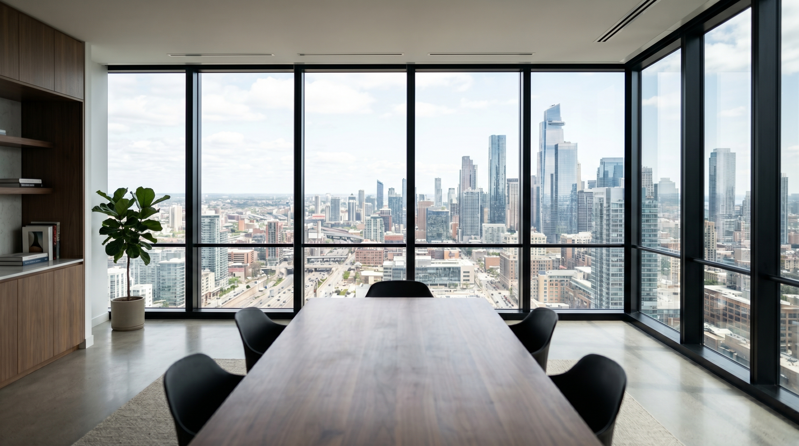 Minimalist office interior with floor-to-ceiling aluminum-framed windows and expansive city view
